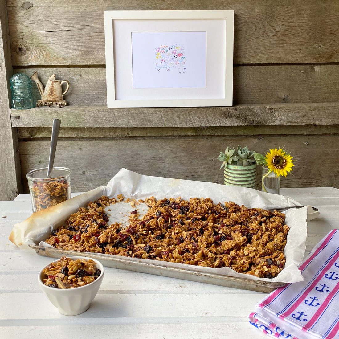 sweet and salty cherry-almond granola in a sheet pan on a rustic tabletop