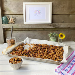 sweet and salty cherry-almond granola in a sheet pan on a rustic tabletop