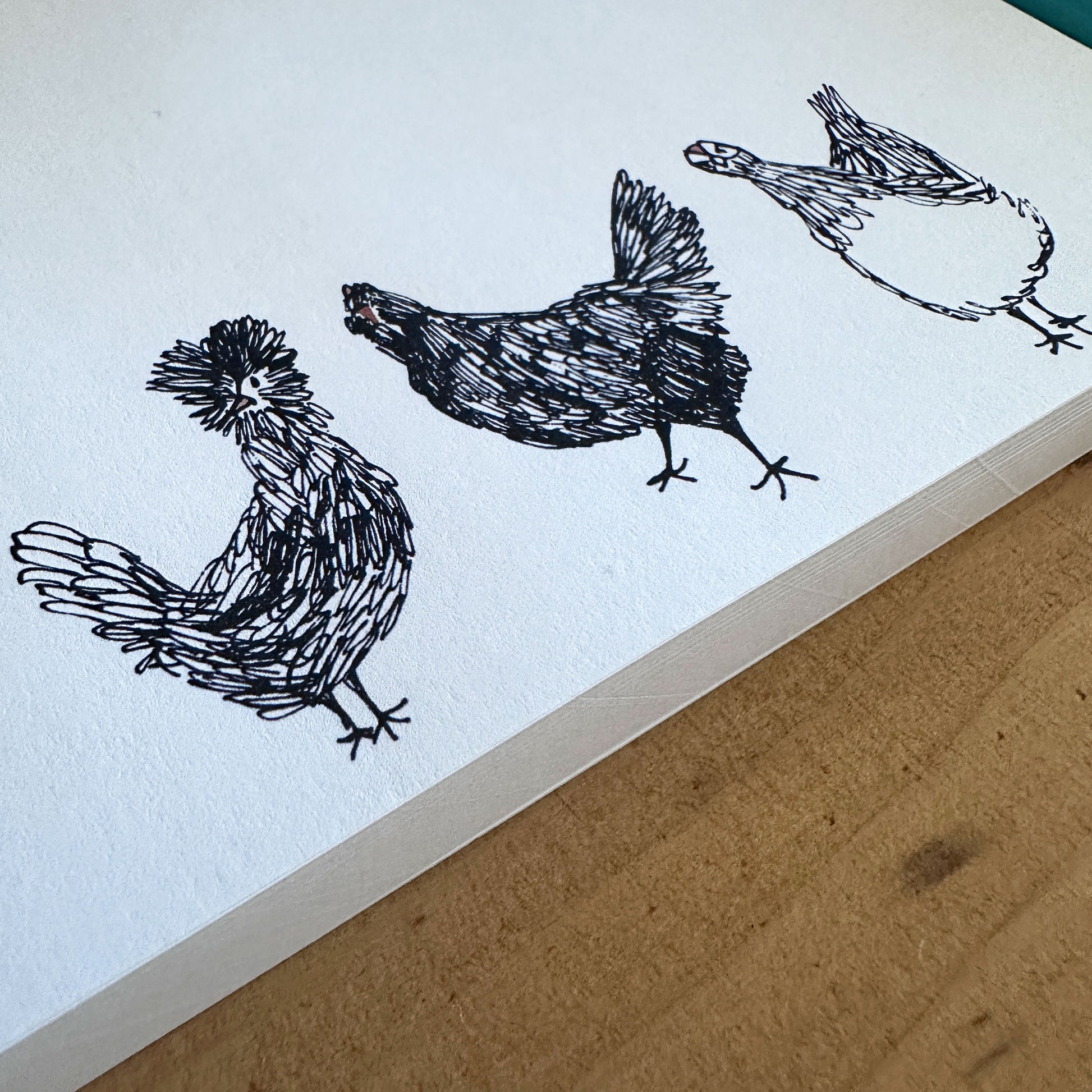 close up view of a 100-sheet notepad with chicken illustration at the bottom