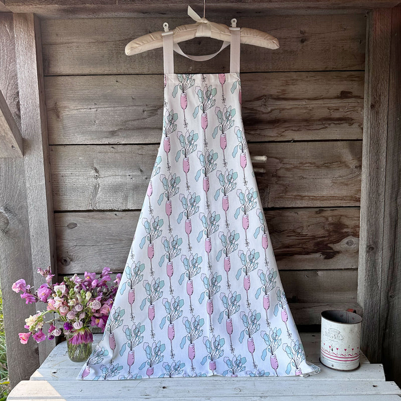 100% cotton aprons printed using eco-friendly inks. This image shows an apron with a pale pink watercolor strawberry pattern and a bright yellow lemon pattern with green leaves